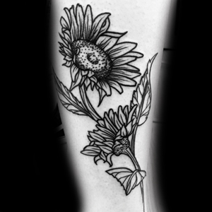 An outline tattoo of a sunuflower in the wind